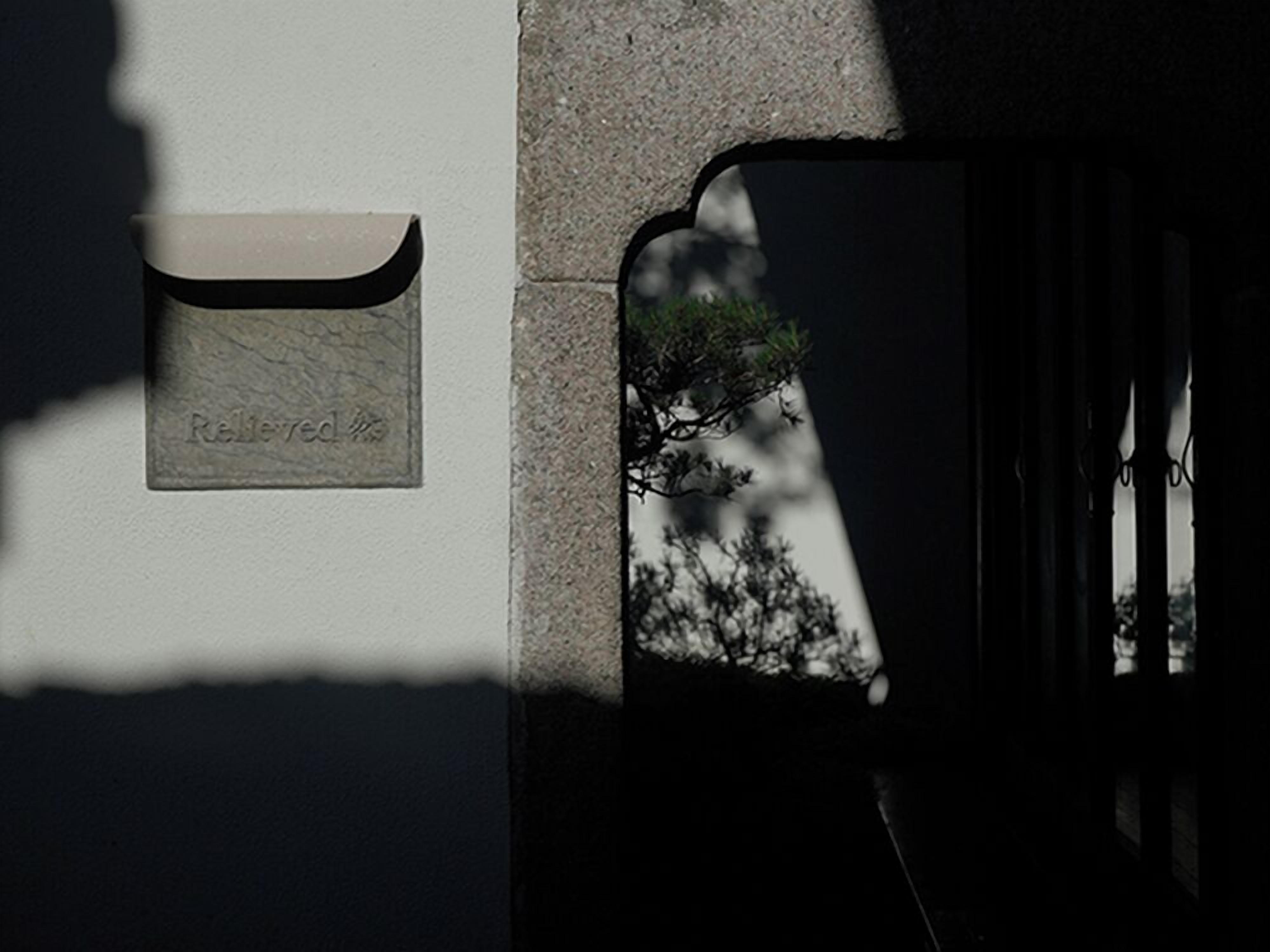 A mailbox with a label reading "Relieved 22" mounted on a wall.