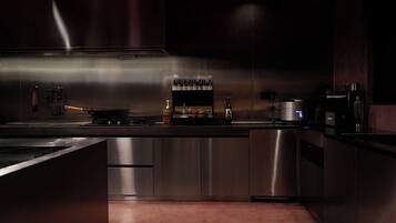 Una cocina moderna con electrodomésticos de acero inoxidable, una vinoteca y una cafetera.