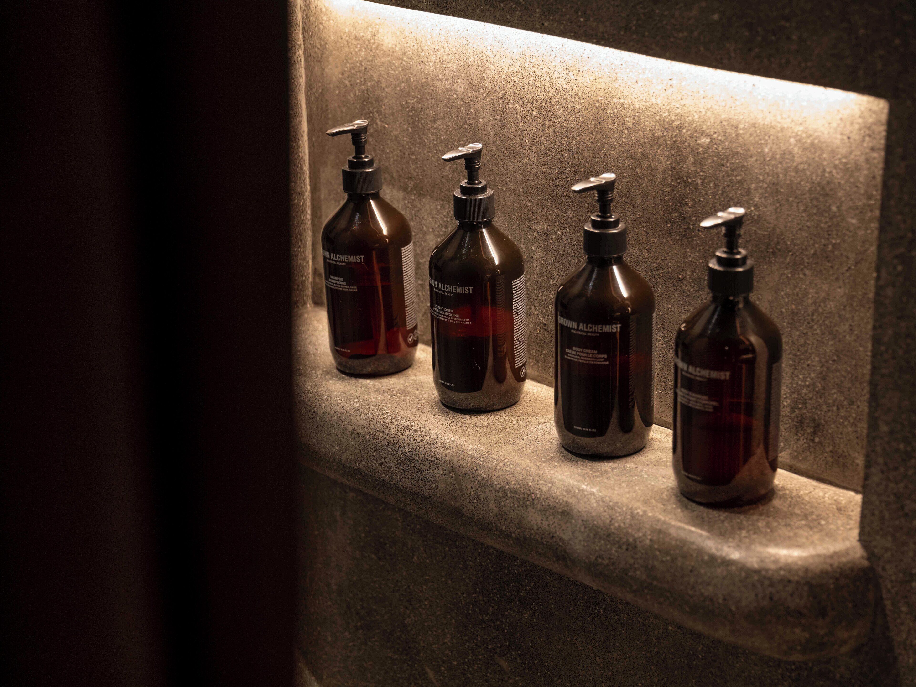 Four bottles of 'Brown Alchemist' on a stone ledge.