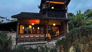 A traditional Chinese building with a two-story structure, a balcony, and a sign indicating a restaurant. - Stayinmind (Xuancheng)