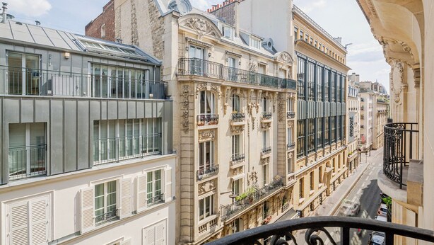 A multi-story building with a mix of architectural styles, including a modern glass facade and ornate classical details. - Blueground | Porte Dauphine, balcony, nr Bois de Boulogne (Paris)