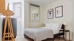 A bedroom with a bed, a dresser, a wooden ladder, a nightstand, and framed pictures on the wall. - Blueground | Porte Dauphine, balcony, nr Bois de Boulogne (Paris)