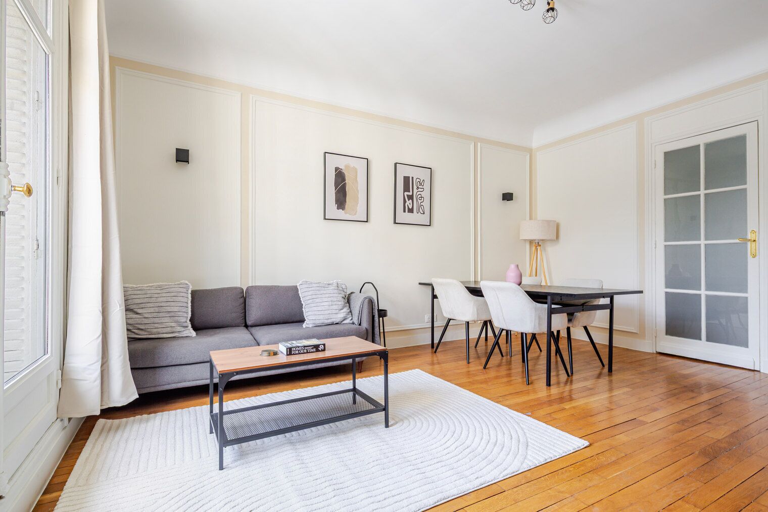 Un salon comprenant un canapé, une table basse et une table à manger avec des chaises.