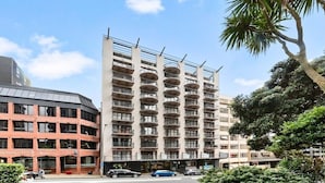 Ein mehrstöckiges Hotel mit modernem Design, ausgestattet mit Balkonen auf jeder Etage und einem zentralen Eingang.
