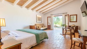 Une chambre à coucher avec un lit, un bureau et une chaise. Il y a une fenêtre avec des rideaux et une vue sur la verdure à l’extérieur.