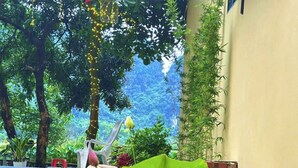 A tranquil garden with a pond, surrounded by rocks and lush greenery. - Tràng An Sunny River Homestay (Ninh Binh)