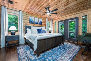 Relax in this serene bedroom with a large bed, bedside tables, and a comfortable chair.