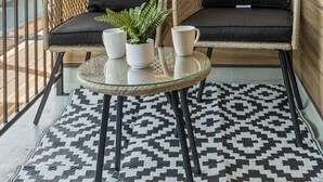 A balcony with two wicker chairs, a small round table, and a patterned rug. - Cozy 1BR|1BA Retreat in Philly (Philadelphia)