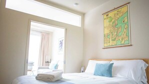 Habitación de hotel con cama, un mapa en la pared y vistas al exterior.