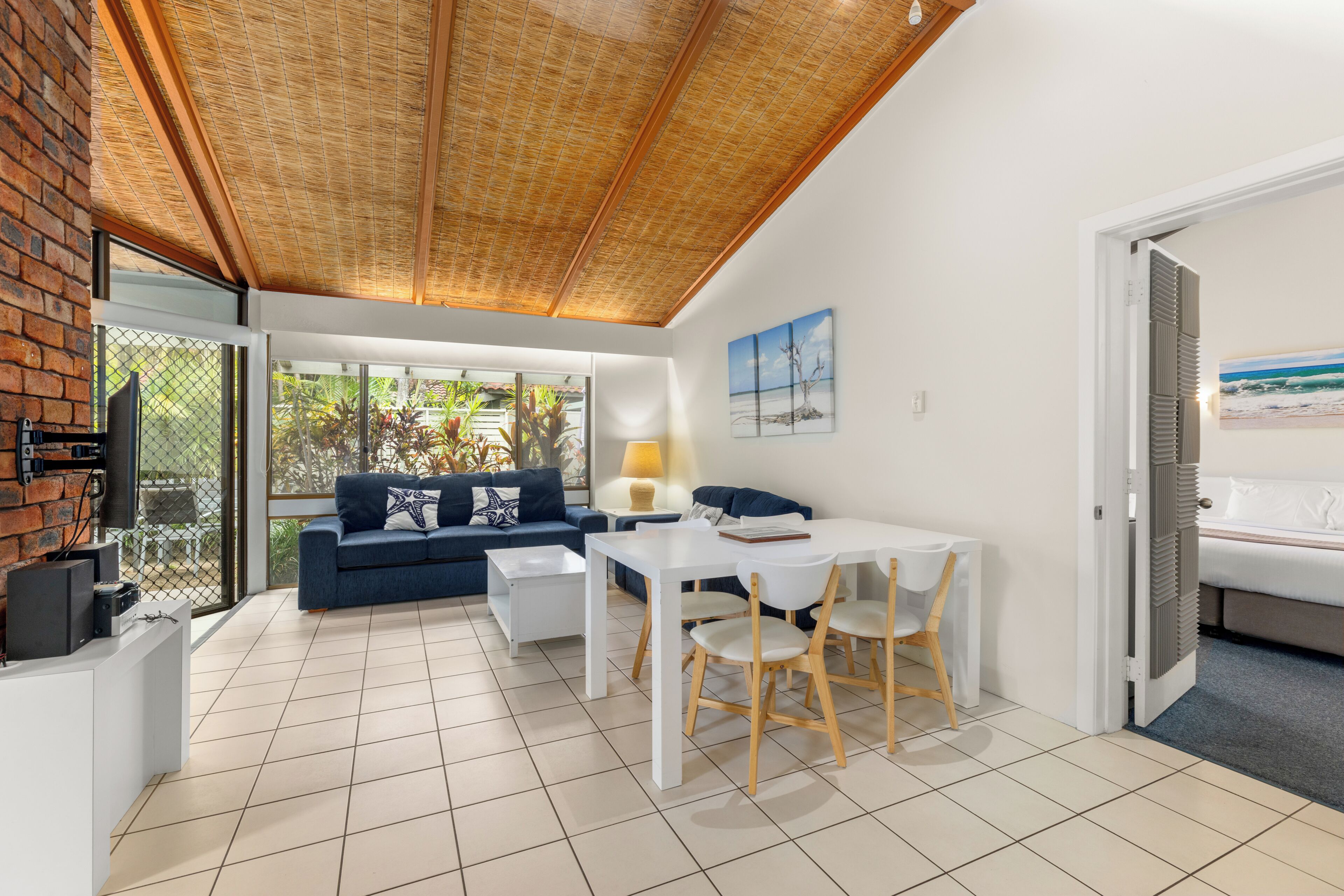 Una sala de estar moderna con comedor, ventanas amplias y vistas al exterior.