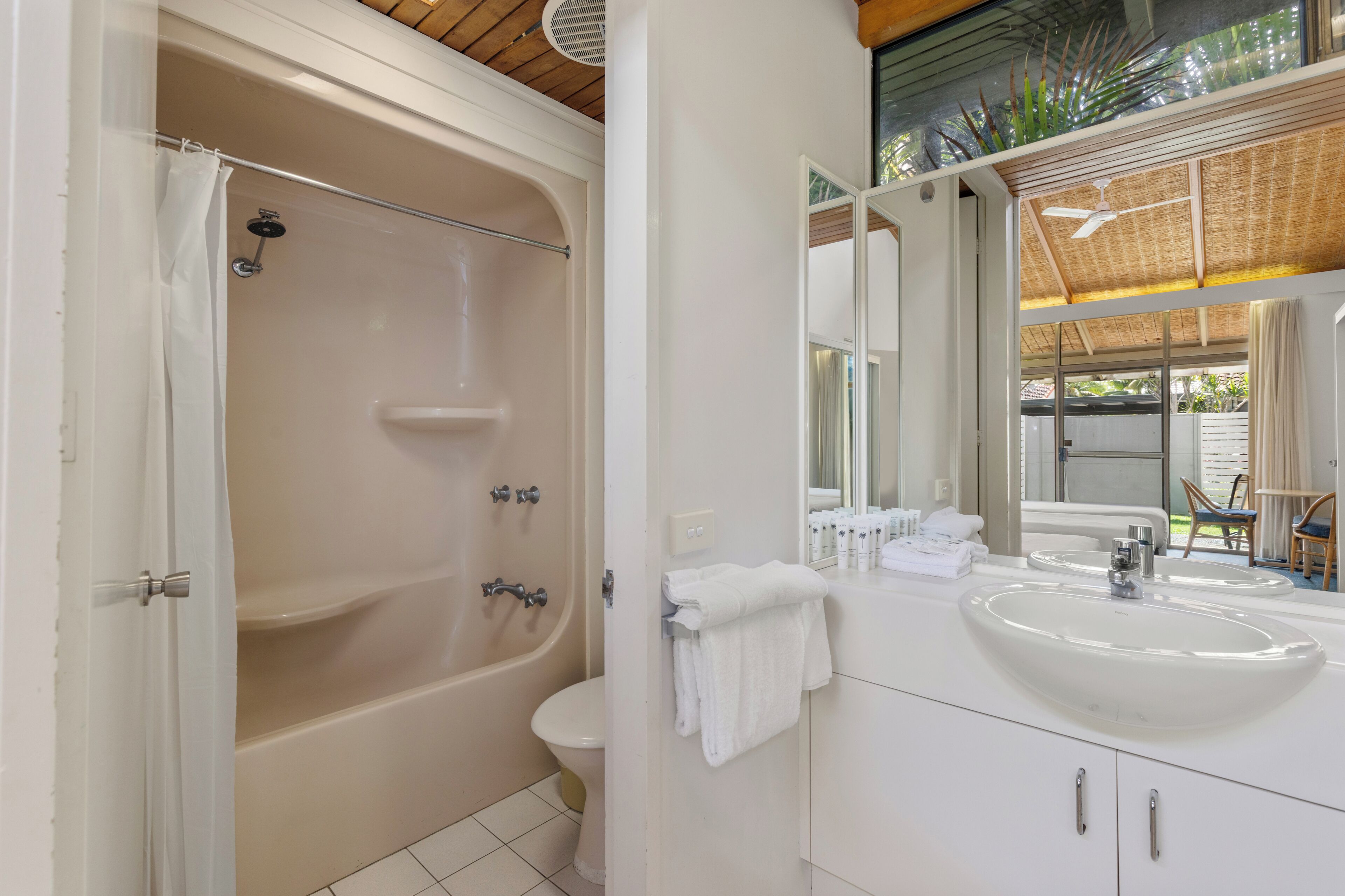 Baño con bañera, inodoro, lavabo y espejo.