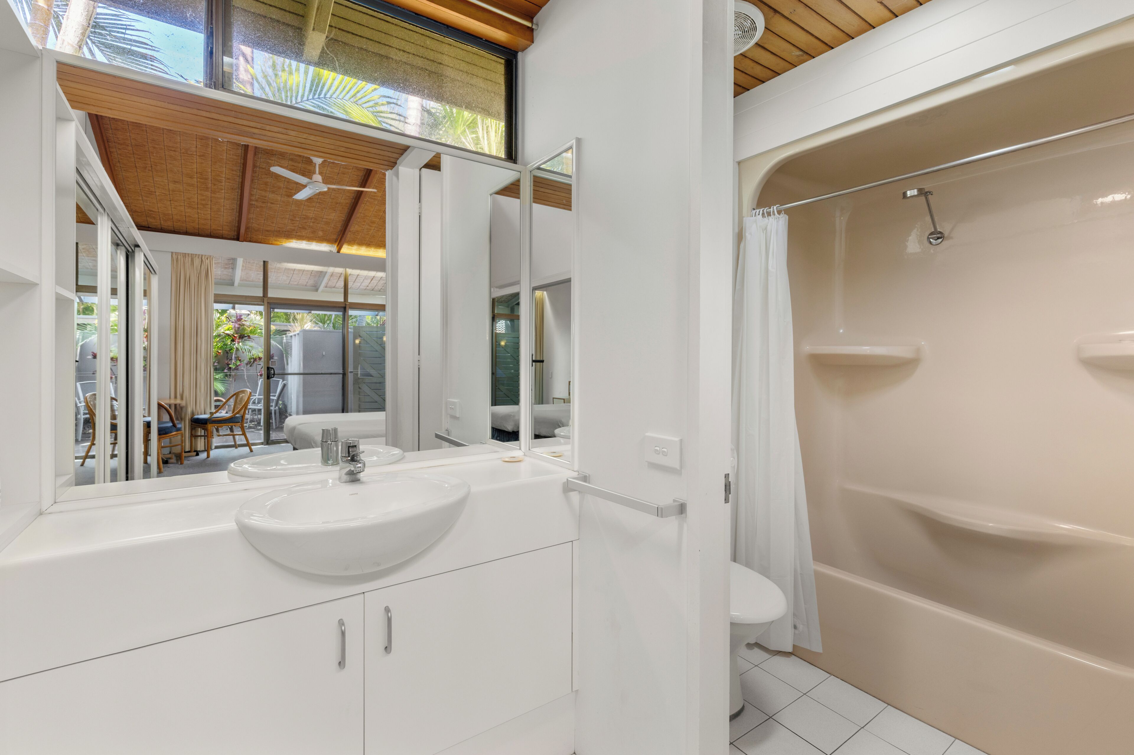 Ein modernes Badezimmer mit einem großen Waschbecken, einem Spiegel und einer Badewanne.