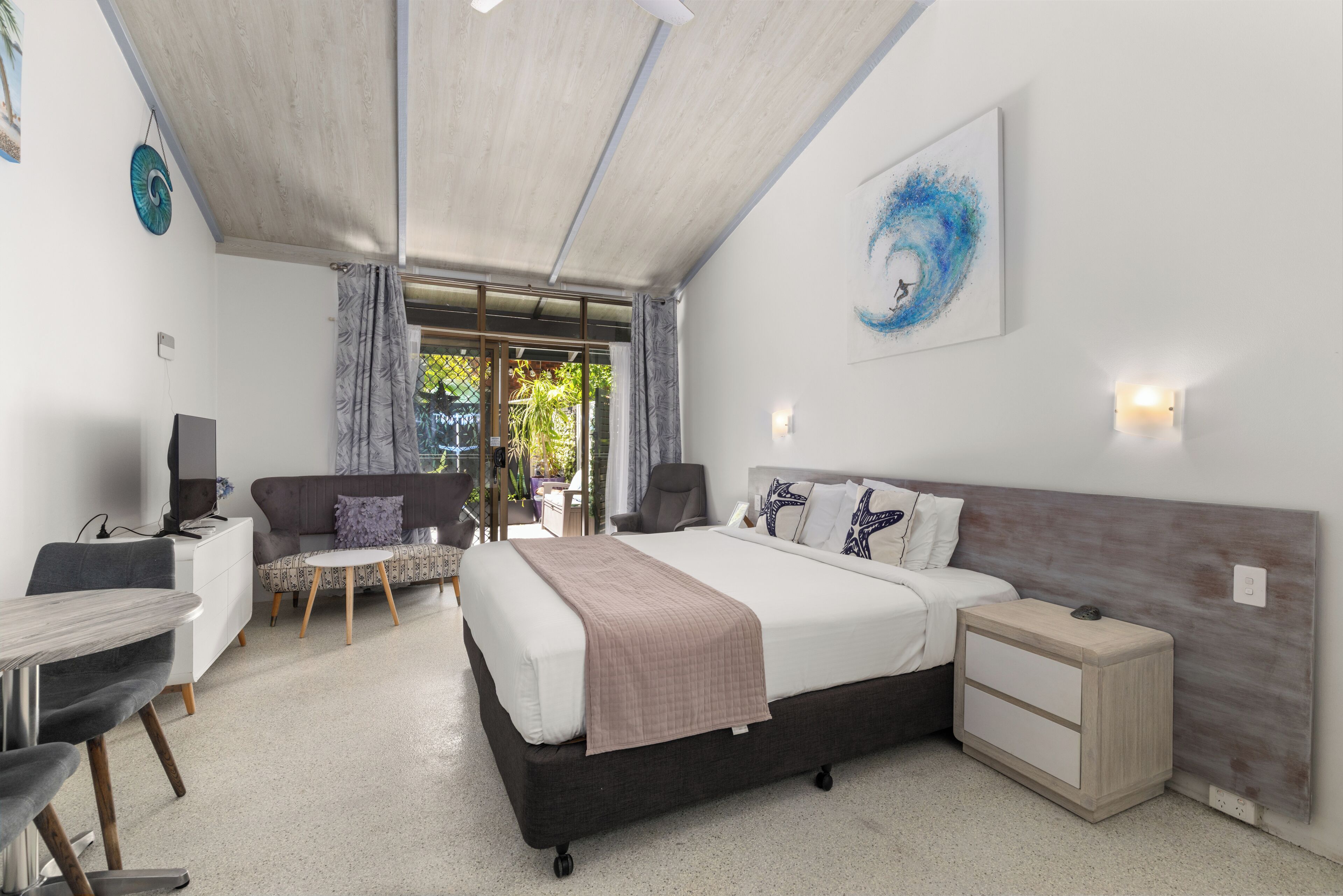 A modern bedroom with a bed, bedside tables, a desk, and a chair.