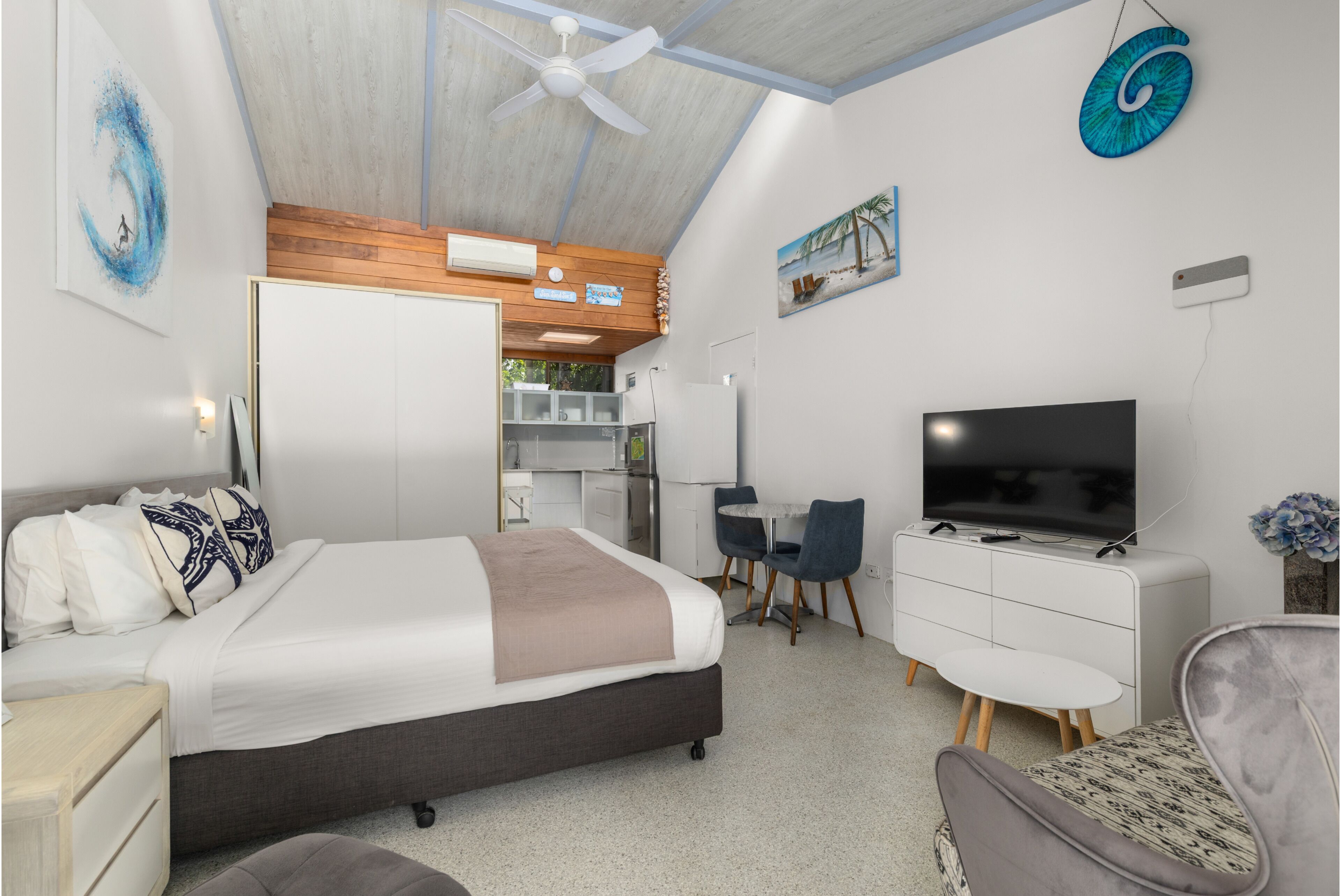 Une chambre à coucher avec un lit, une télévision, un bureau et une chaise.