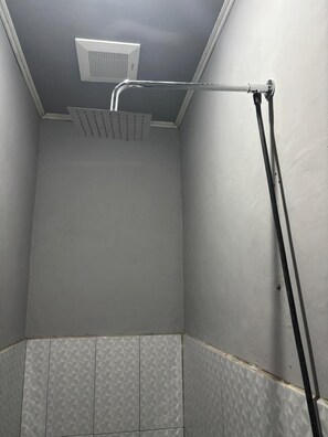 A shower with a ceiling-mounted head and a flexible hose.