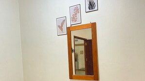 A small, clean room with two single beds, a wooden headboard, and a mirror on the wall. - Rara Guest House Raja Ampat (Waisai)