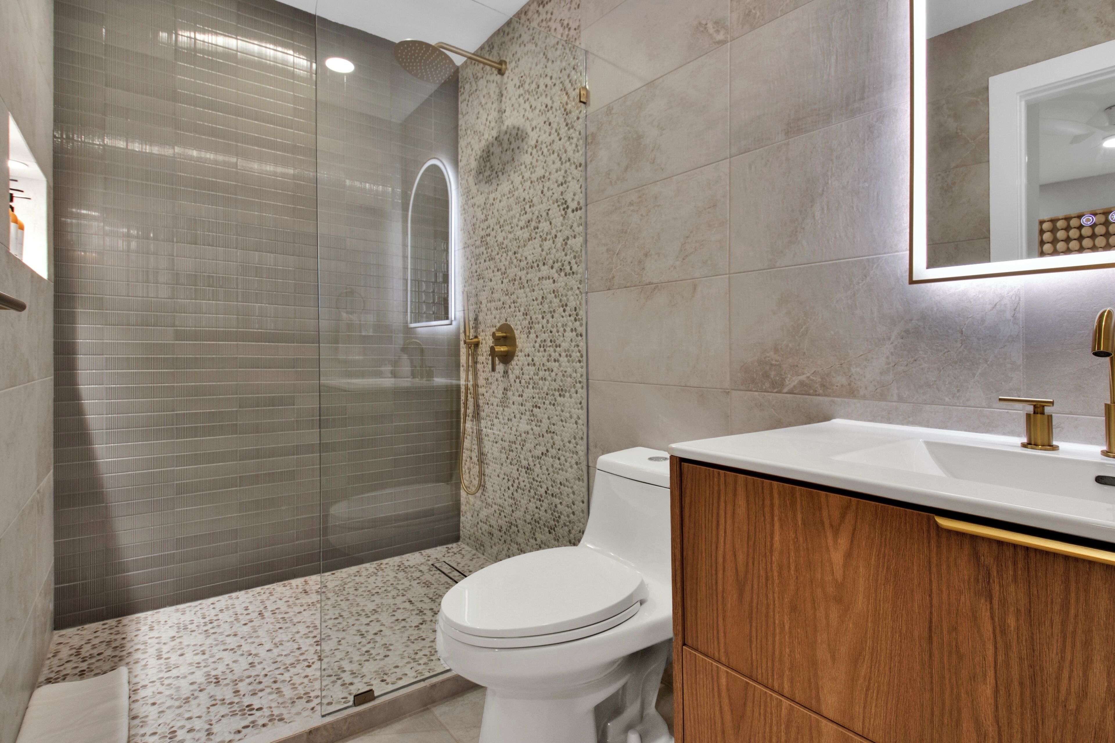 Un baño moderno con ducha, inodoro y tocador.