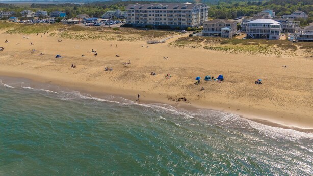 An aerial view of a beach with a hotel complex in the background.
