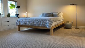 A bedroom with a bed, bedside lamp, and a nightstand with a lamp. - Charming and Spacious 2B + 2.5 Bath Townhome (Pasadena)