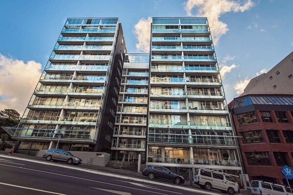 A modern high-rise building with multiple floors, large windows, and a prominent entrance area.