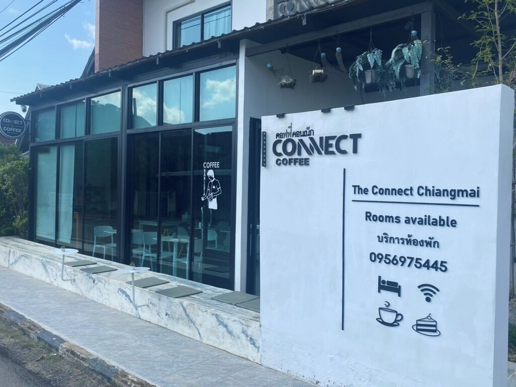 Una cafetería llamada 'Connect Coffee' con un letrero que anuncia disponibilidad de habitaciones y un número de contacto.