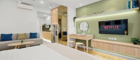Una sala de estar moderna con sofá, una mesa de centro y un televisor montado en la pared.