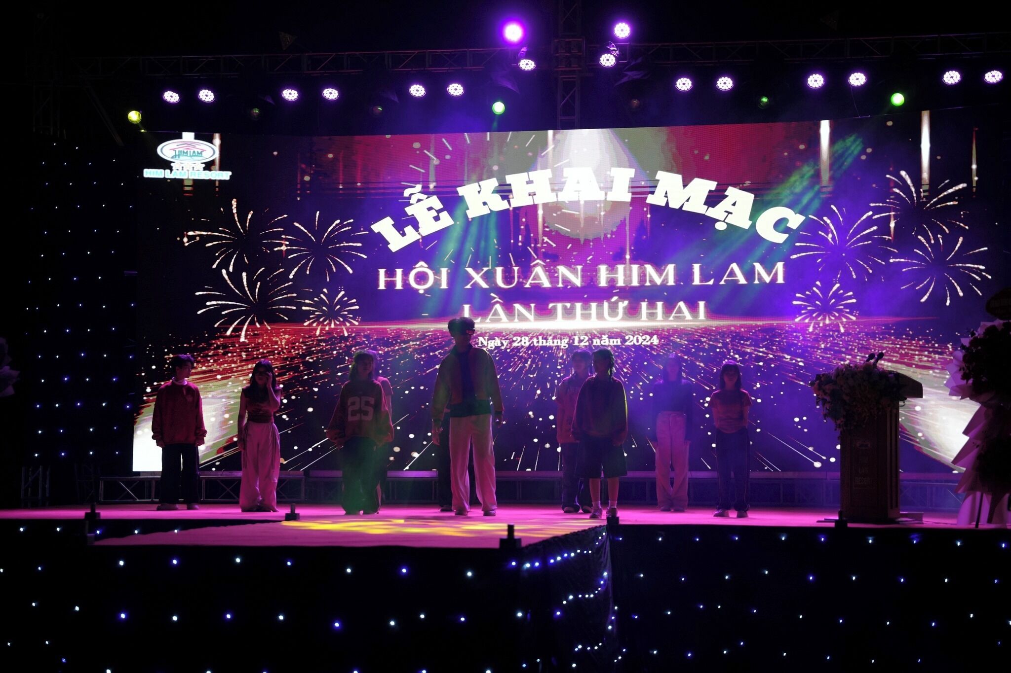 A stage with a large screen displaying text and fireworks.