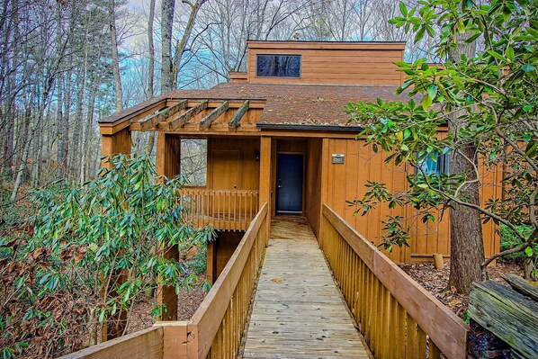 A wooden cabin with a covered porch and a wooden walkway leading to the entrance. - Pet-Friendly Blue Ridge Stay w/ Resort Perks (Sapphire)