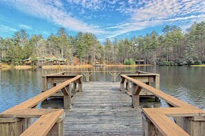 A wooden dock leading to a lake with cabins in the background. - Pet-Friendly Blue Ridge Stay w/ Resort Perks (Sapphire)