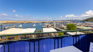 A marina with boats docked, a clear sky, and a view of the coastline. - BILOCALE ACQUAMARINA - BILOCALE ACQUAMARINA (Marciana Marina)