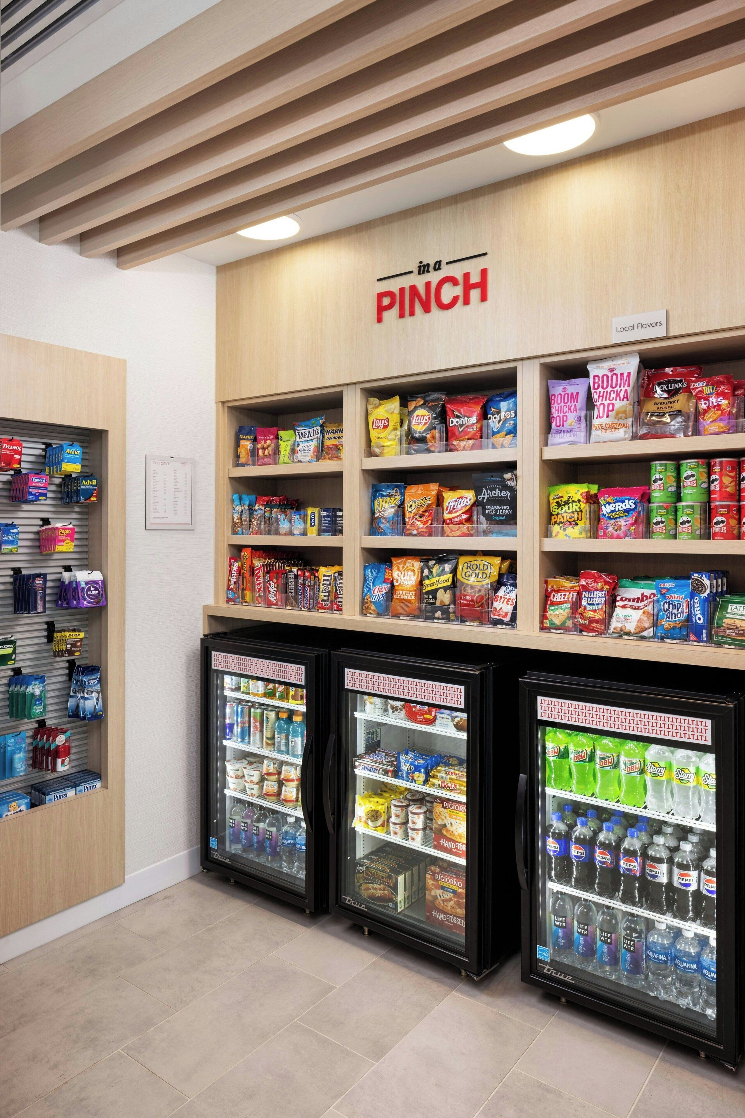 Zona de venta automática con opciones de bocadillos y bebidas, que incluye una sección de 'Sabores Locales' y dispensadores refrigerados.