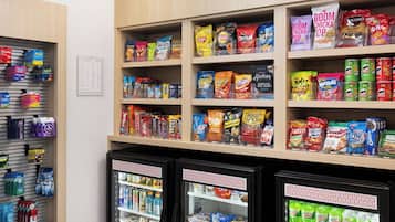 Zona de venta automática con opciones de bocadillos y bebidas, que incluye una sección de 'Sabores Locales' y dispensadores refrigerados.