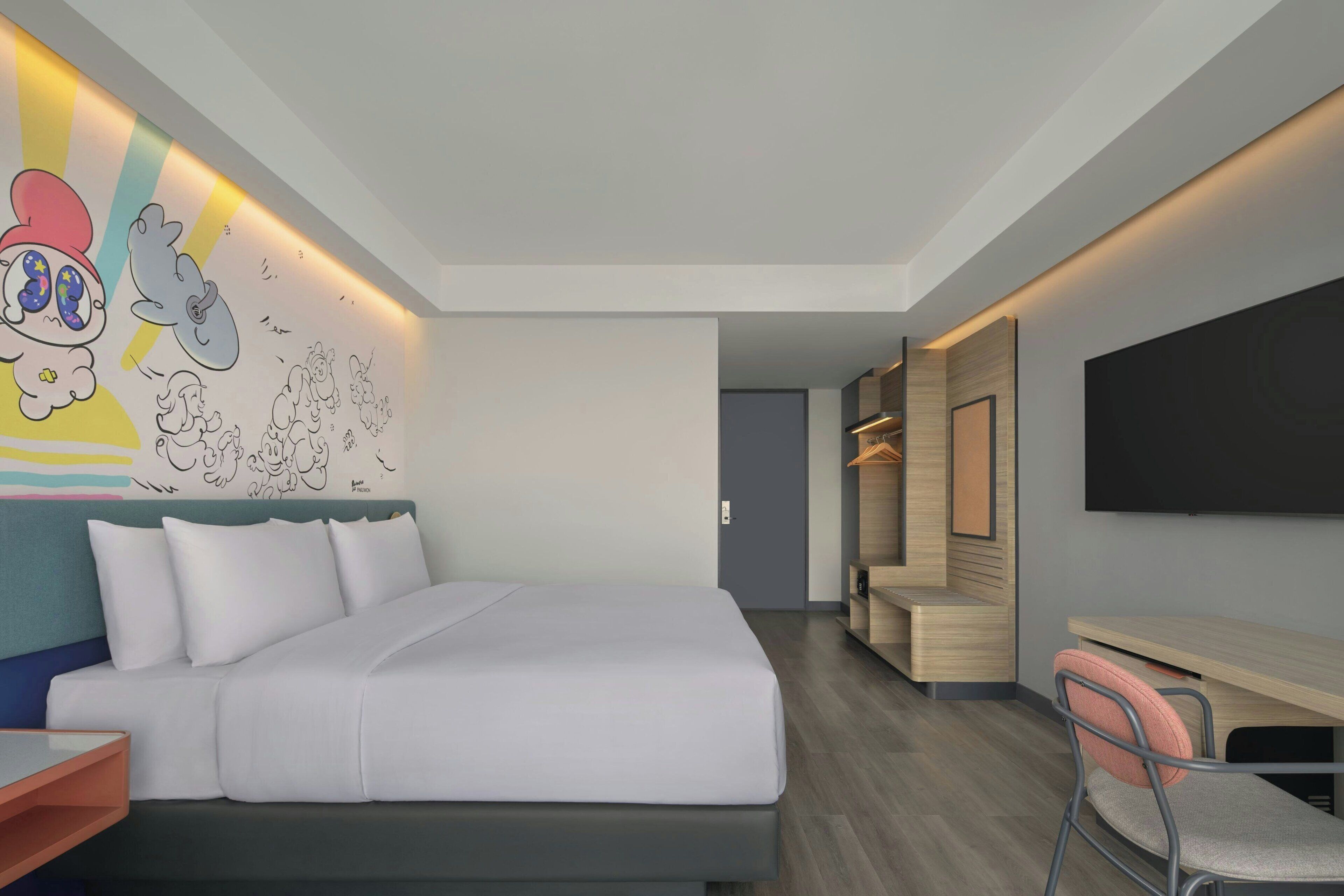 Una camera d'albergo moderna con un letto grande, una scrivania e una TV.