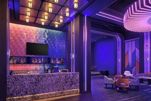 A modern bar area with a marble countertop, a flat-screen TV, and a variety of bottles. - Aloft by Marriott Surabaya Pakuwon City (Surabaya)