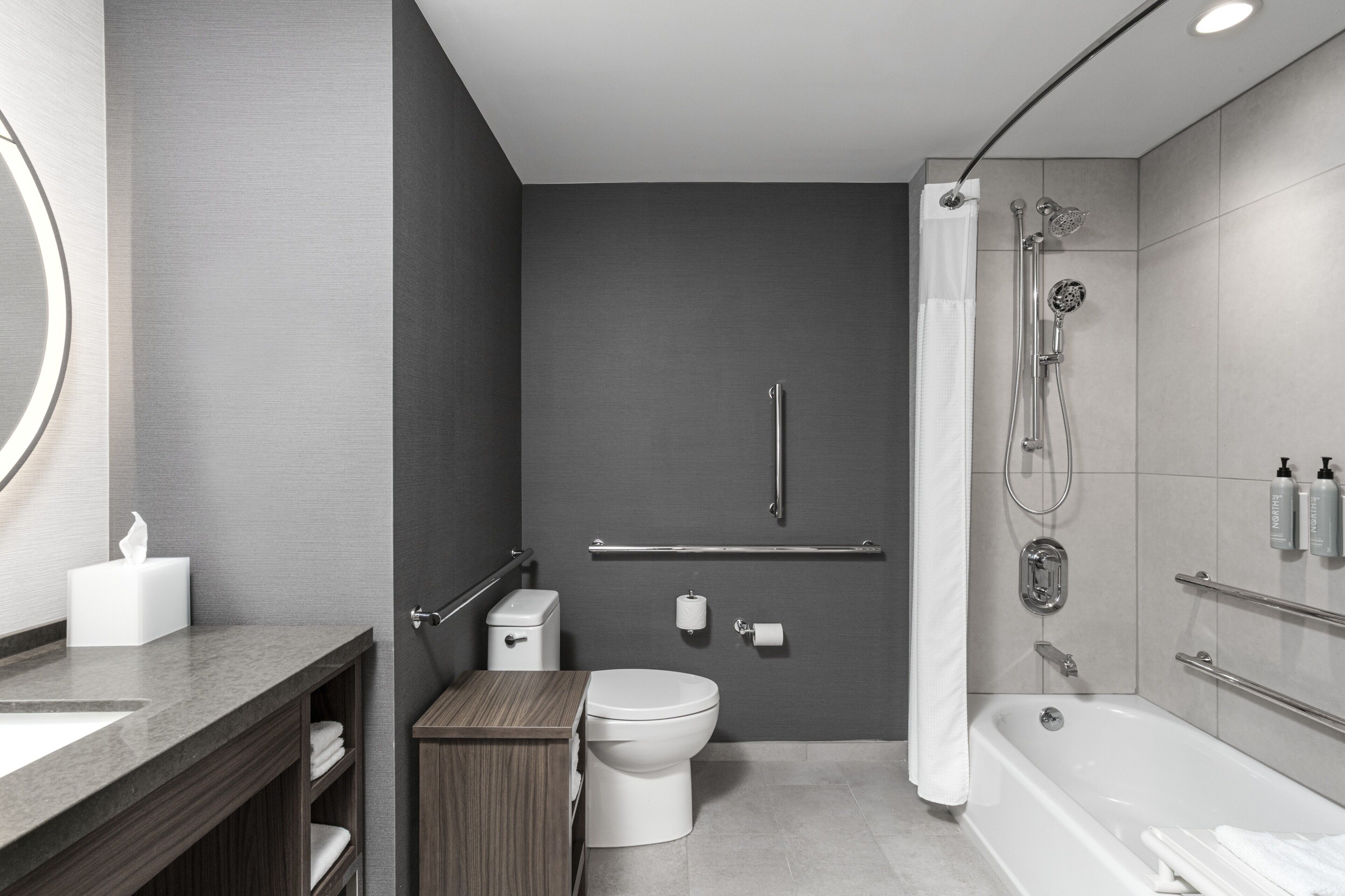 A modern bathroom with a toilet, sink, and shower area.