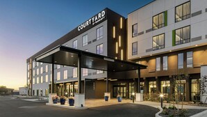 A Courtyard by Marriott hotel with a modern design, featuring a covered entrance and a landscaped area with planters. - Courtyard by Marriott Lewiston (Lewiston)