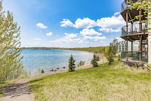 A lakeside property with a wooden deck and a view of the lake. - Breathtaking Lake Views | Studio, 2 Queen | Pools (Two Harbors)