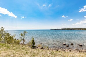 A clear view of a lake with a rocky shoreline and sparse vegetation. - Breathtaking Lake Views | Studio, 2 Queen | Pools (Two Harbors)
