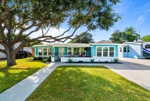 A single-story house with a front porch, a tree in the yard, and a clear sky. - Newly Remodeled 3 Bed/2 Bath, Hot Tub, Pet Friendly, Corpus Christi (Corpus Christi)