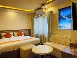 Suite – junior, byutsikt | Safe på rommet, skrivebord, skrivebord for bærbar PC og lydisolert