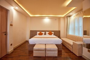 A hotel room with a large bed, a sofa, and a small table. - The Samrat Palace (Kathmandu)