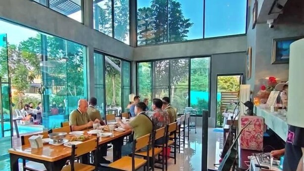 Une salle à manger spacieuse avec de grandes fenêtres, un piano et une vue sur l’extérieur.