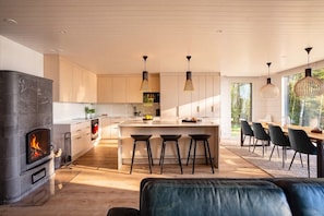 A modern kitchen with a central island, bar stools, and pendant lighting. - Stay North - Parmaranta (Ylöjärvi)
