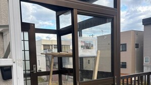 A modern building entrance with glass doors and a wooden structure inside. - KOTONOHA (Otaru)