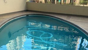A swimming pool with a tiled edge and a metal ladder. - Dazzling Waikiki Apt Sleeps 7-excellent A/C & PARKING included (Honolulu)