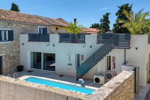Ein modernes Gebäude mit Pool, einer Treppe und einer Steinfassade.