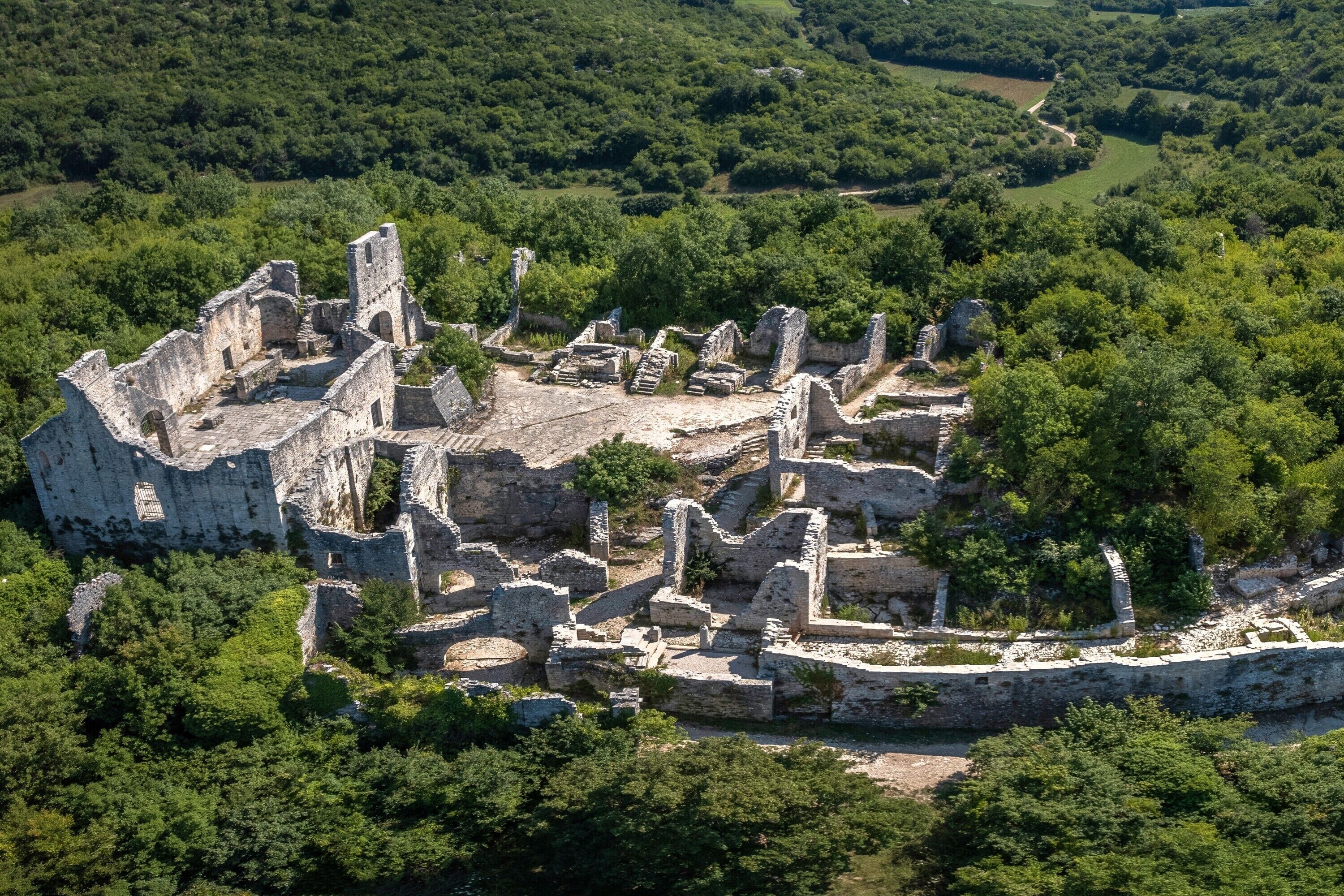 Une vue aérienne de ruines antiques, entourées d’une végétation luxuriante.