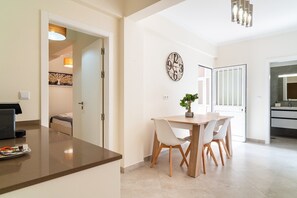 Una cocina moderna con comedor, un reloj en la pared y una planta en maceta.