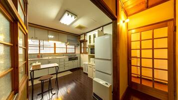 A compact kitchen with a refrigerator, stove, and bar stools.