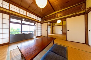 Una habitació tradicional japonesa amb fons de tatami, una taula de fusta baixa i portes corredisses.